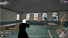 a man is holding a gun in a room with a lot of windows .