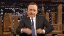 a man in a suit and tie is making a funny face .