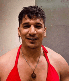 a man wearing a red bikini top and a necklace