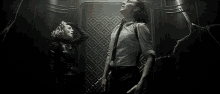 a man and a woman are standing next to each other in a dark room and looking up .