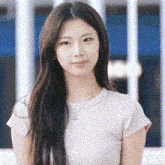 a woman with long hair is wearing a white t-shirt and necklace .
