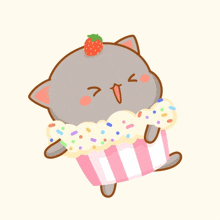 a cat with a strawberry on its head is holding a cupcake