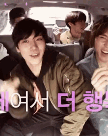 a group of young men are sitting in the back seat of a car with chinese writing on the back