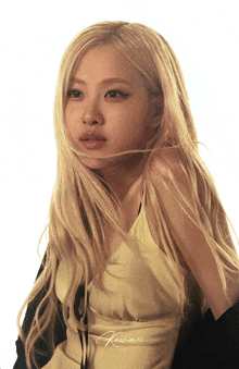 a woman with long blonde hair is wearing a yellow dress and black cardigan