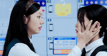 two girls are touching each other 's faces in front of a sign that says ' locker room '