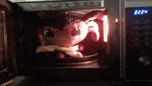 a stuffed animal is being cooked in a microwave oven with the time reading 2:22