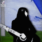 a black and white photo of a person playing a guitar with a tiktok watermark