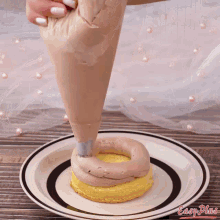 a person is frosting a cake on a plate with easy plans written on the bottom