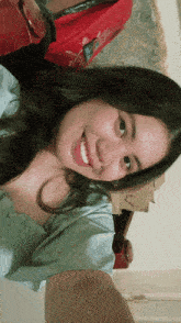 a woman taking a selfie with a red bag in the background