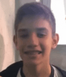 a young boy with braces on his teeth is smiling and making a funny face .