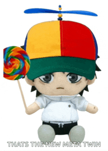 a stuffed toy wearing a colorful hat and holding a lollipop that says that 's the new meta twin