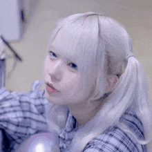 a girl with white hair and pigtails smiles for the camera