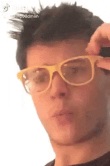 a close up of a man wearing glasses and a black shirt .