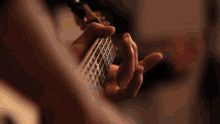 a close up of a person playing a guitar in a dark room