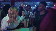 a man and a woman are sitting at a table with drinks in their hands
