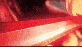 a person is holding a red sword in their hand in front of a red background .