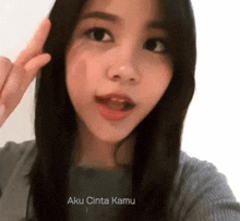 a woman is taking a selfie with the words aku cinta kamu written below her