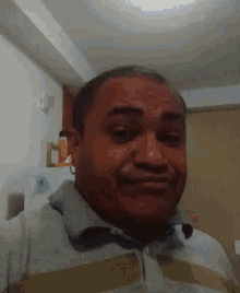 a man in a striped shirt is smiling in a kitchen