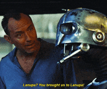 a man in a blue shirt is talking to a robot and the robot says lanupa you brought us to lanupa