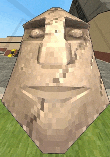 a pixelated statue of a man 's face is sitting on a grassy field .