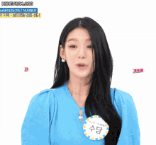 a woman in a blue shirt with a name tag that says secret number on it