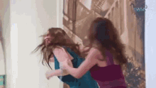 two women are having a fight in a room .
