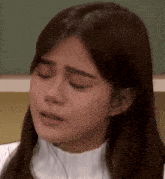 a close up of a woman 's face with her eyes closed .