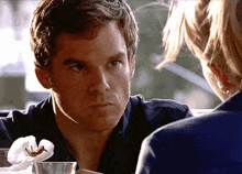 a man in a blue shirt is looking at a woman