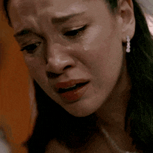 a close up of a woman 's face with a tear running down her cheek