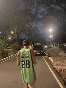 a man wearing a green jersey with the number 28