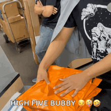 a man in a black shirt is holding an orange bag that says high five bubby