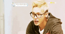 a young man wearing glasses and a black hoodie is looking at something .