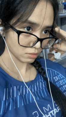 a woman wearing glasses and ear buds is wearing a shirt that says 2 am