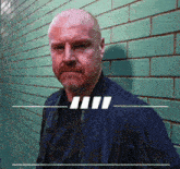 a man in a blue jacket stands in front of a green tiled wall
