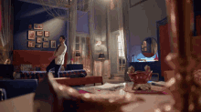 a man in a suit walks through a living room filled with furniture and pictures on the wall