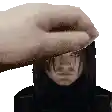 a hand is putting something on a man 's head