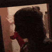 a woman 's head is visible through a window in a room