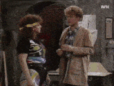 a man and a woman are standing next to each other in a room with a sign that says ark