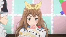 a girl with a bow on her head eating a cake