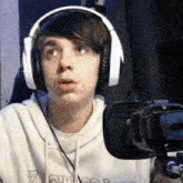 a young man wearing headphones and a sweatshirt that says ' earl ' on it