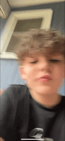 a blurry picture of a boy 's face with a window in the background .