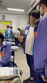 a group of young men are standing in a classroom .