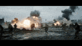 a group of soldiers are in a field with a large explosion going off in the background