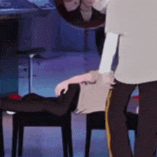 a man is standing next to a woman who is sitting on a chair .
