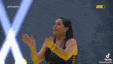 a woman is dancing in front of a yellow sign that says bbbo .