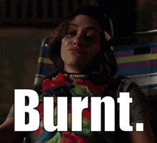 a woman is sitting in a chair with the words burnt written on the screen