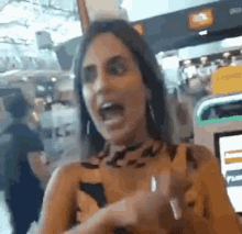 a woman in a leopard print dress is making a funny face with her mouth open .