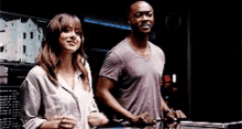 a man and woman are standing next to each other in a dark room .
