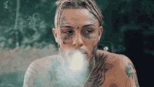 a man with a tattoo on his face smoking a cigarette