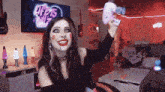 a woman holds up a pink hair dryer in front of a screen that says life is miz
